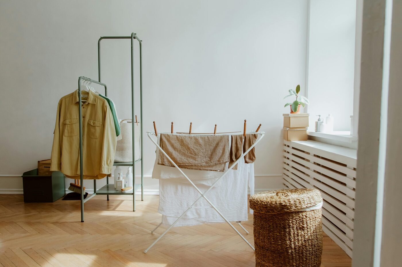 A dehumidifier positioned beside an indoor laundry drying rack