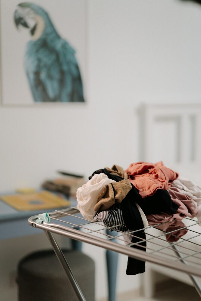 A dehumidifier helping dry clothes indoors on a laundry rack